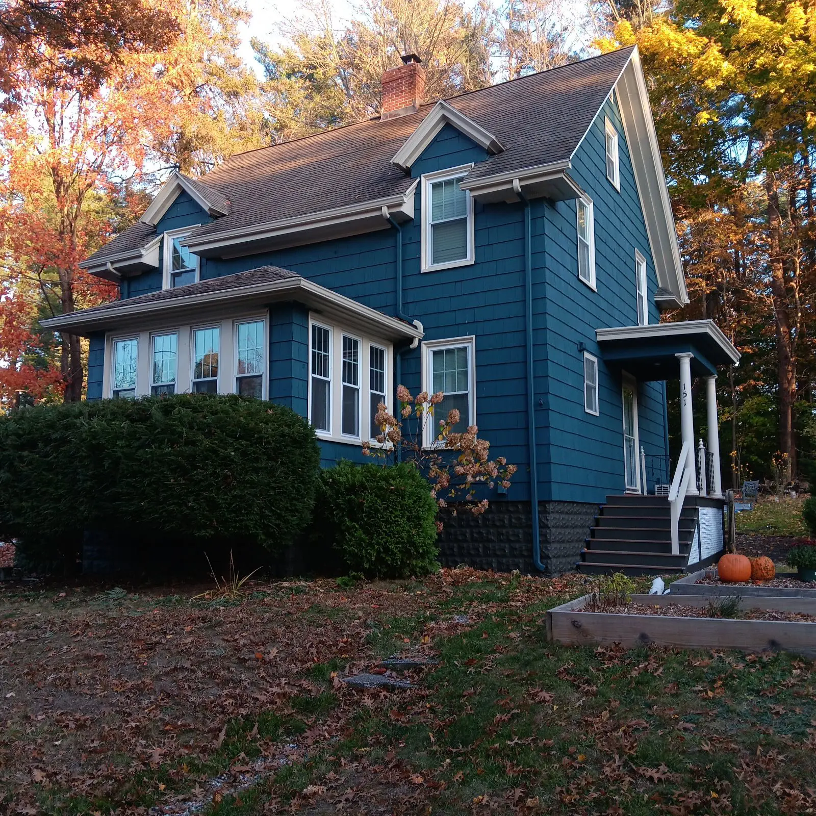Residential exterior painting project featuring a beautifully painted blue home with crisp white trim and seasonal curb appeal completed by Zellers Painting & Contracting.