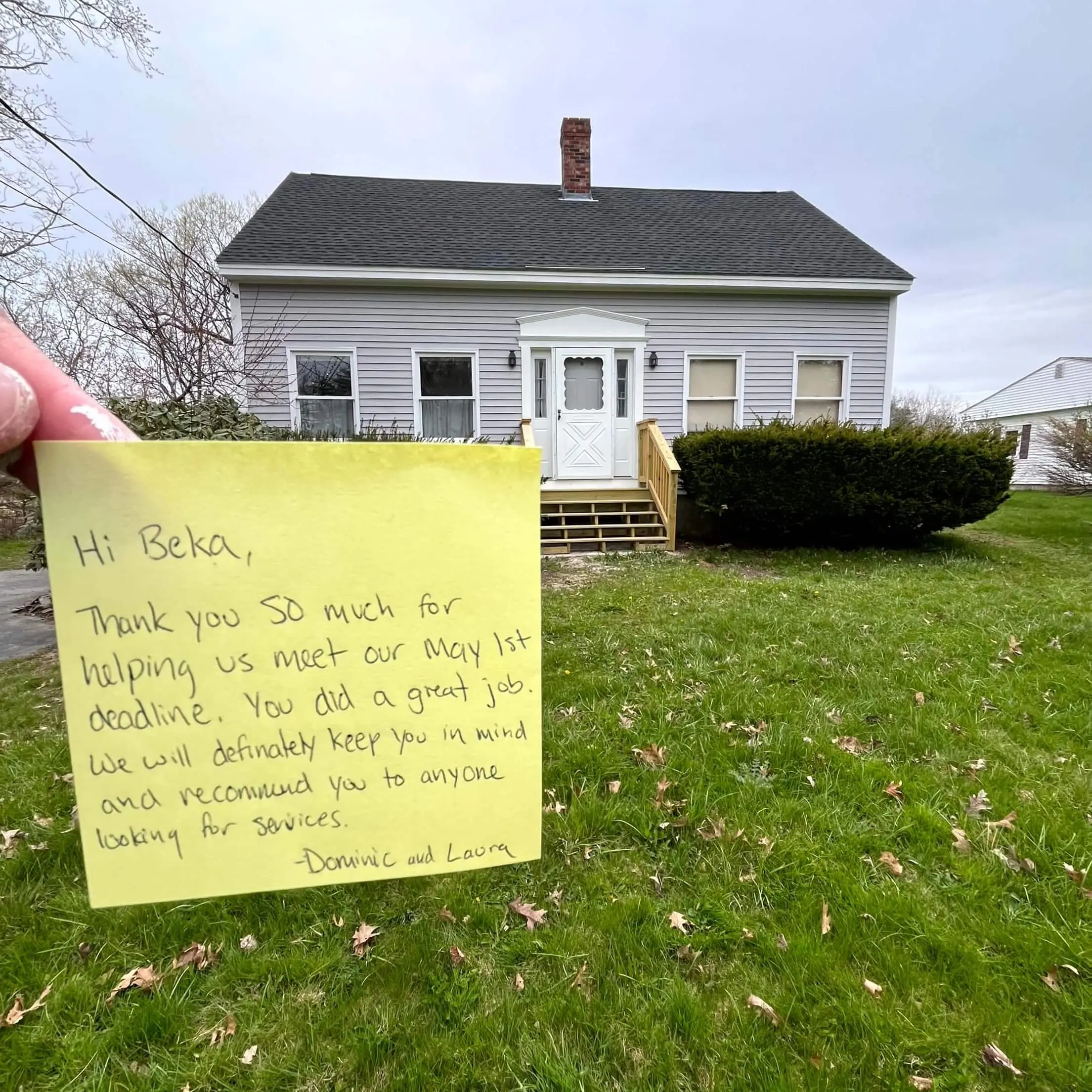 owner of Zellars painting holding up a handwritten note from a happy customer in from of a finished painting project in portland maine