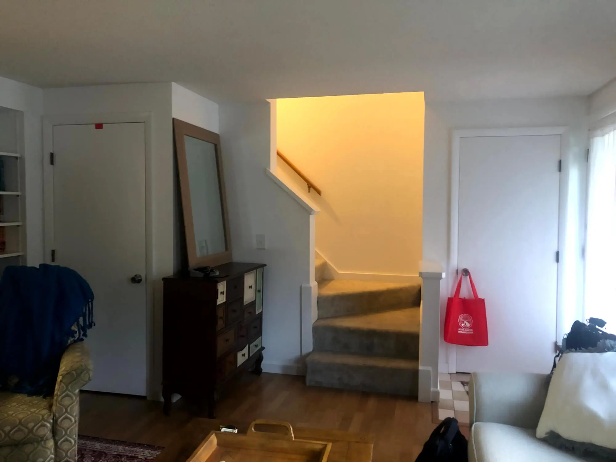 Bright, professionally painted living room and stairwell interior with smooth white walls and clean trim, enhancing the home’s open feel by Zellers Painting & Contracting