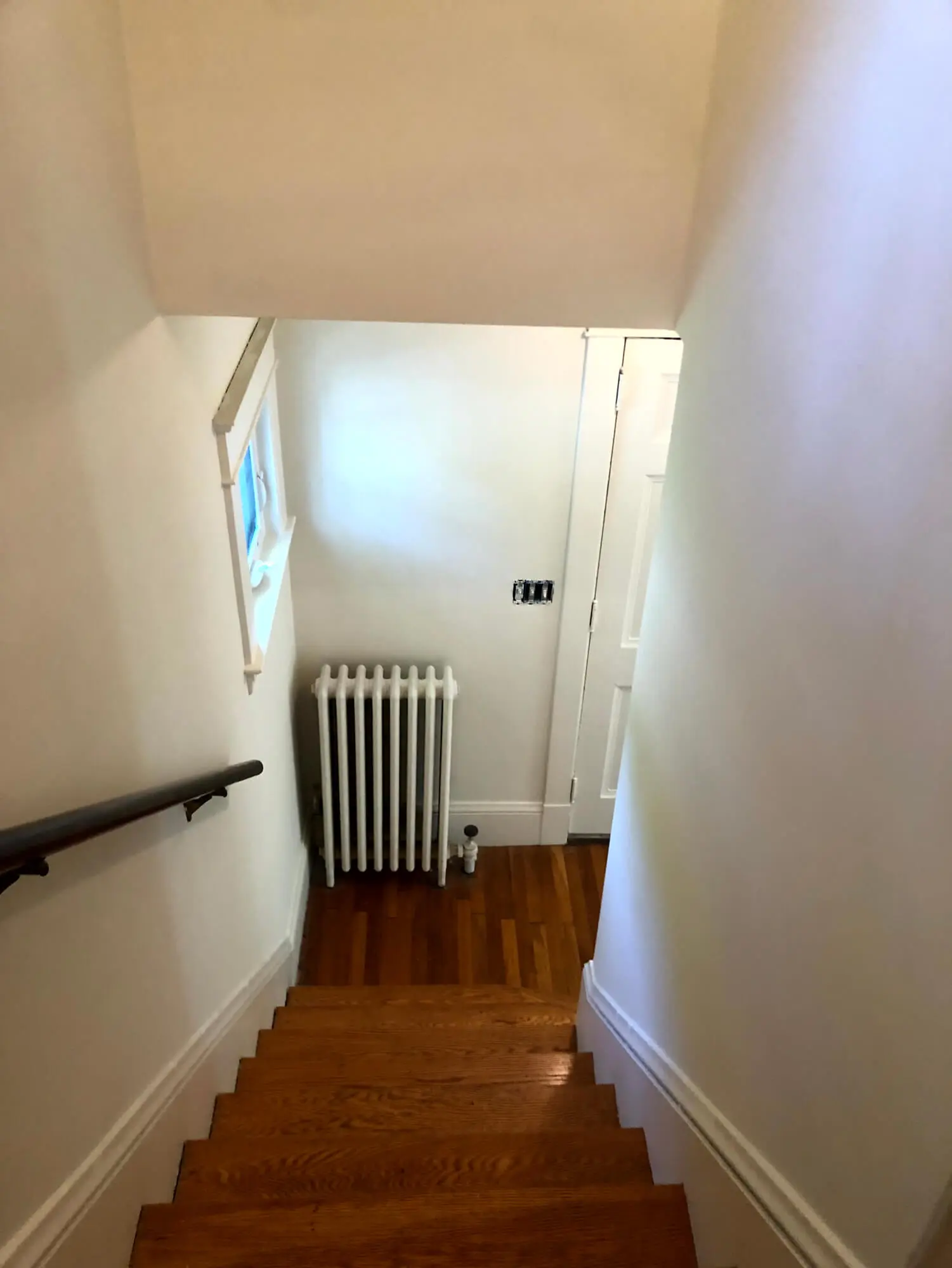 Freshly painted interior stairwell with smooth white walls and clean trim lines, delivering a bright, polished finish by Zellers Painting & Contracting.